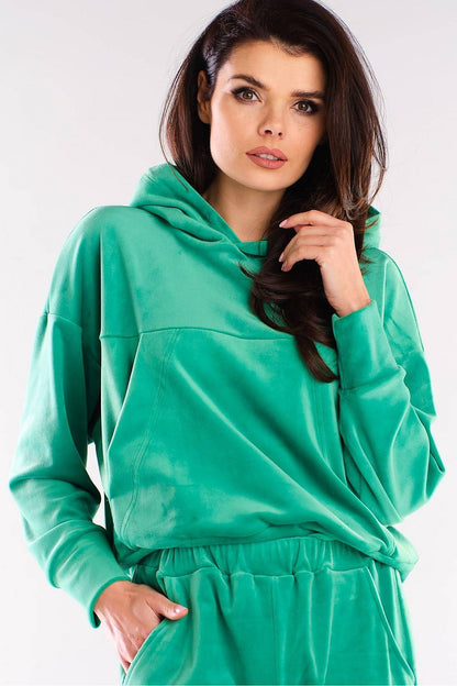 Model showcasing a luxury green velour hooded kangaroo sweatshirt by Awama, combining elegance and relaxed aesthetics.