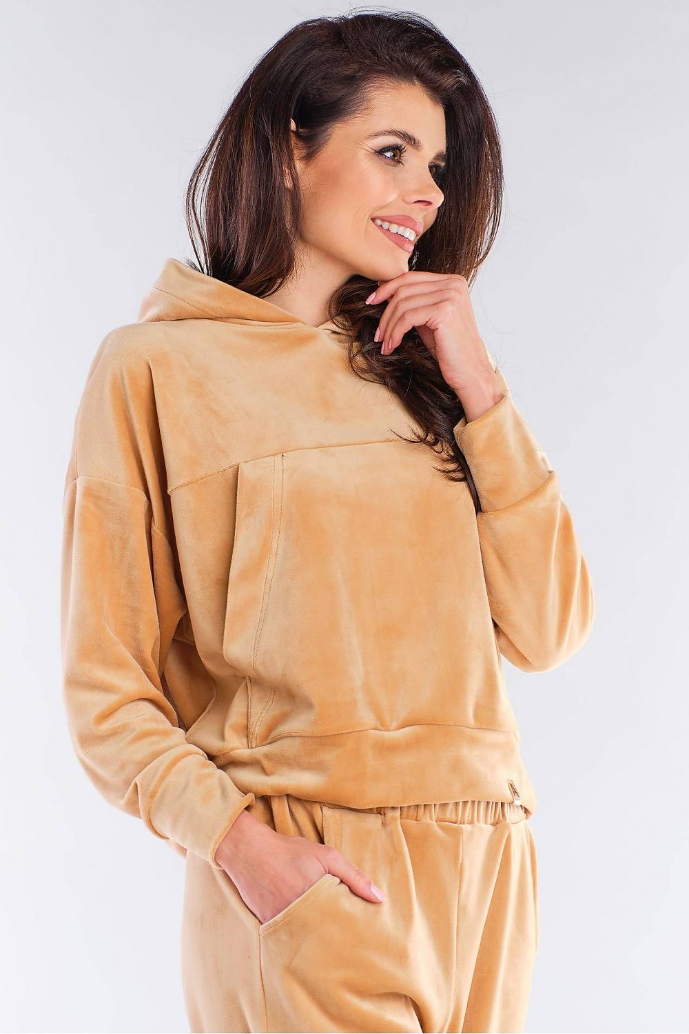 Side profile of the luxury velour hooded kangaroo sweatshirt by Awama in beige, highlighting the comfortable loose fit and elegant design details.