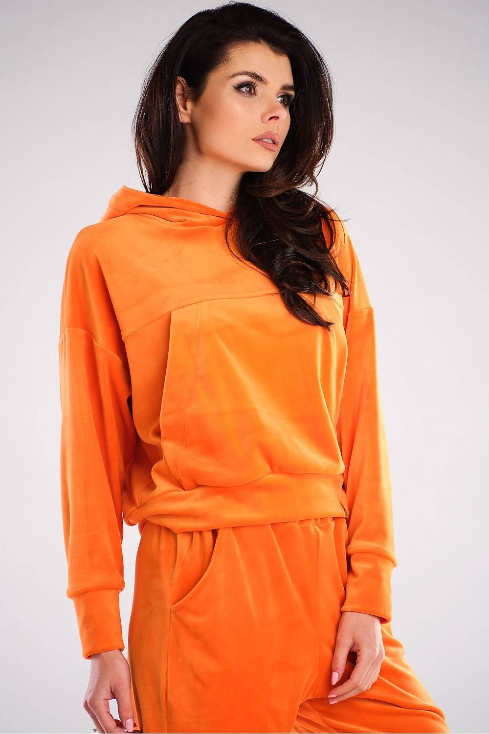 Chic front view of a luxury velour hooded kangaroo sweatshirt by Awama, styled in bright orange, featuring a loose cut and sophisticated detailing.