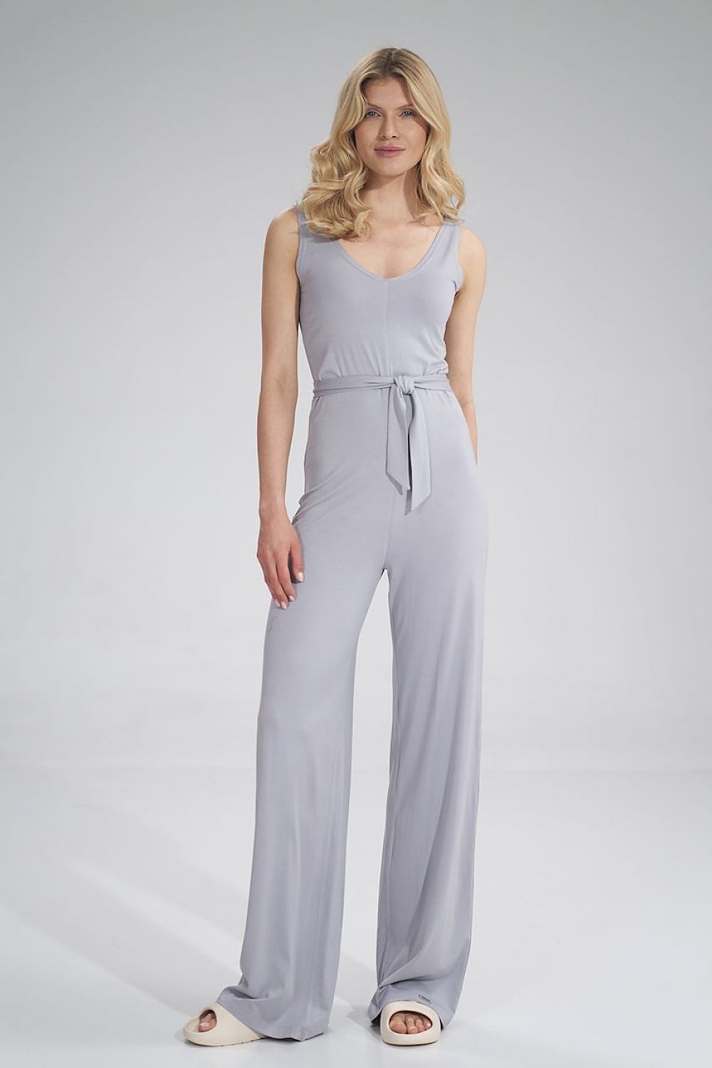 Elegant Figl sleeveless summer jumpsuit in soft grey, featuring a sweetheart neckline and a stylish waist tie. The wide-leg design exudes luxury and sophistication, perfect for warm weather occasions.