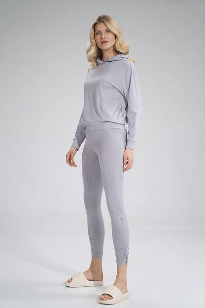 Stylish view of a woman in Figl luxury long leggings paired with a matching grey hoodie, highlighting the chic and contemporary design.