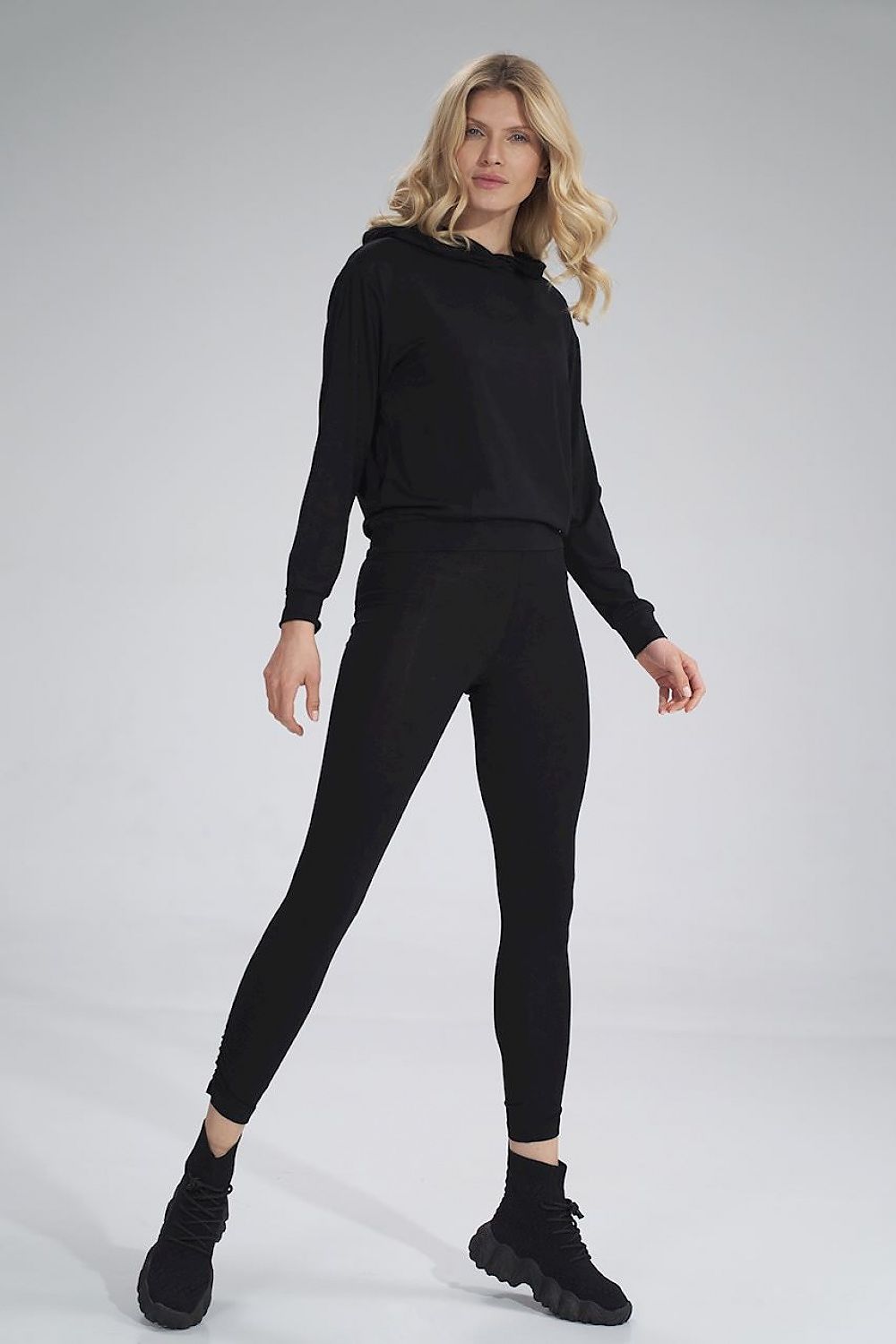 Elegant black long leggings by Figl, paired with a stylish black hoodie and smart black sneakers, showcasing casual luxury.