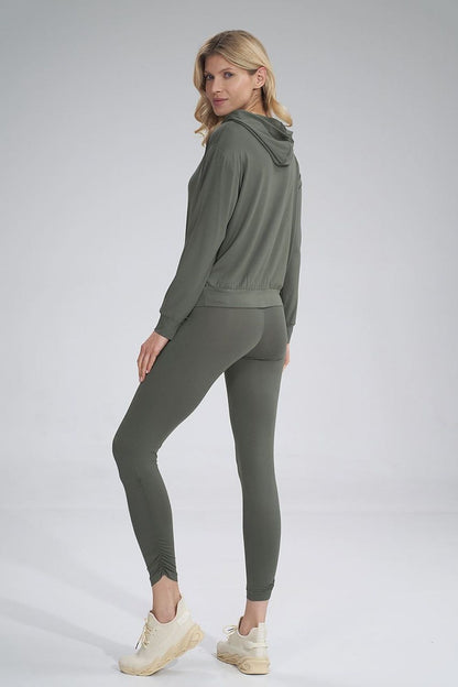 Elegantly styled model showcasing Figl luxury long leggings with creased design and wide waistband, paired with a chic hooded top, perfect for a fashionable and comfortable look.