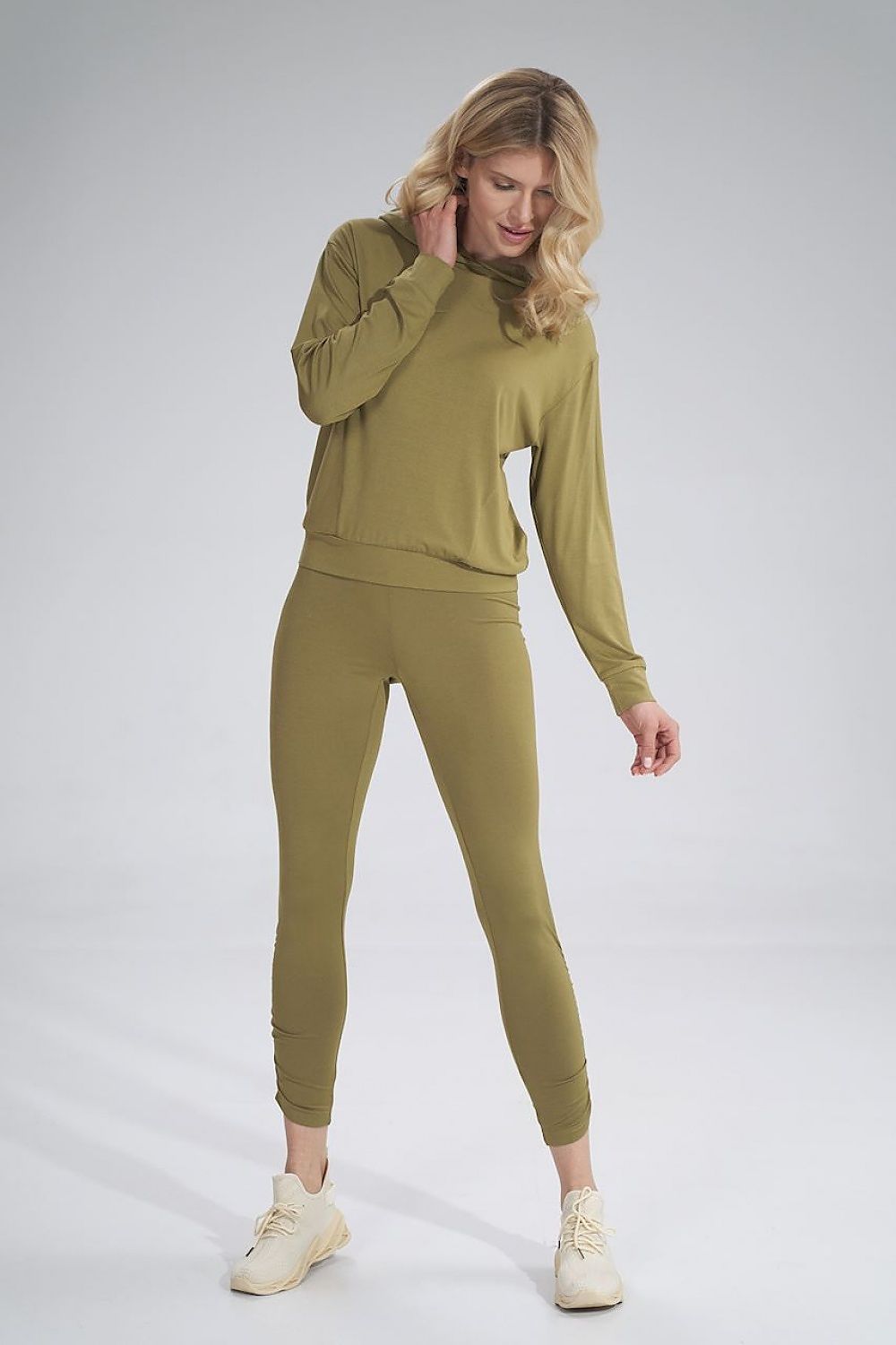 Chic model presenting Figl long leggings with a sophisticated creased design, wearing a matching hooded top, embodying luxury and comfort for everyday attire.