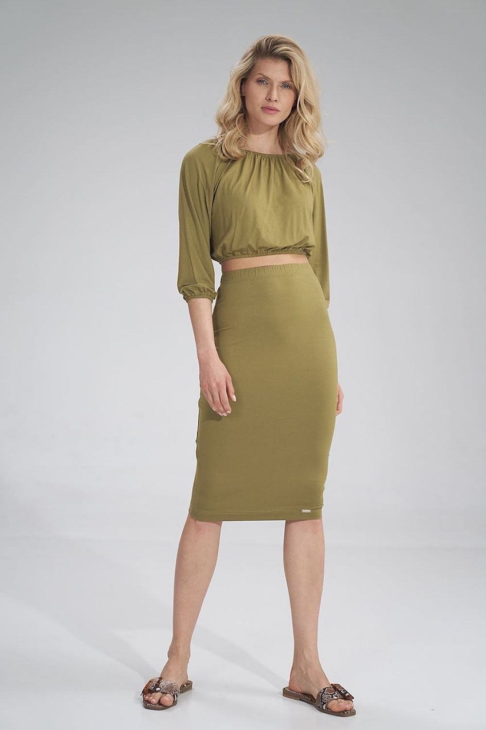 Stylish front view of a model in an olive green pleated blouse and skirt set, exuding luxury and elegance by Figl.