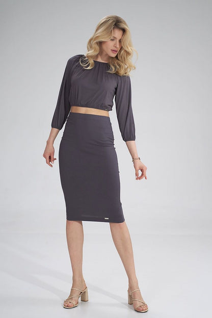 Dynamic pose of a model in a dark grey pleated blouse and fitted skirt from Figl, perfect for sophisticated occasions.