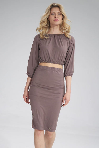 Stylish woman presenting the Figl pleated blouse in a soft taupe hue, featuring 3/4 sleeves and a comfortable fit, perfect for versatile luxury wear.