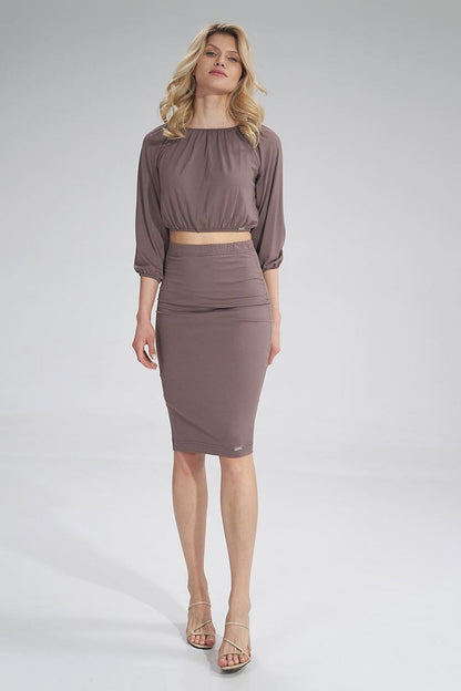 Sophisticated model showcasing the Figl pleated blouse in taupe, with trendy gathered detailing and a seamlessly matching skirt, embodying contemporary luxury.