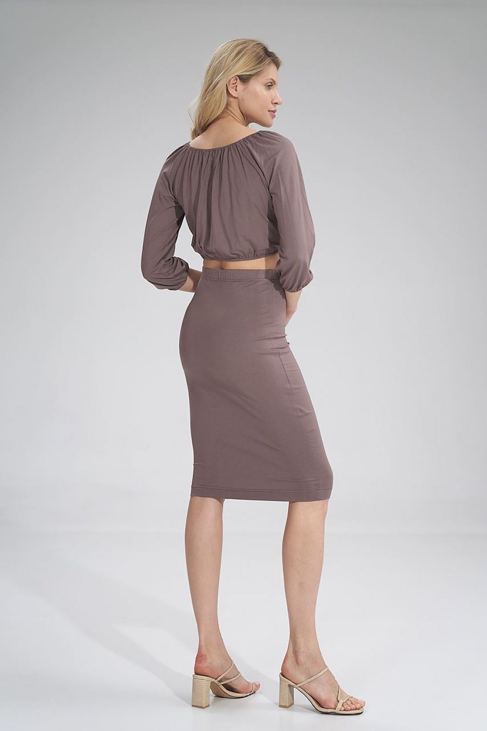 Elegant back view of a woman wearing a 3/4 sleeve pleated blouse by Figl paired with a fitted skirt, showcasing luxurious style and comfort.