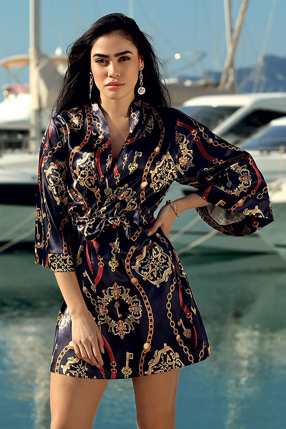 Luxury DKaren Satin Bathrobe with Expressive Pattern and 3/4 Sleeves - Mid-Thigh Length, showcased by a model against a picturesque yacht backdrop, highlighting its elegant design and luxurious fabric.
