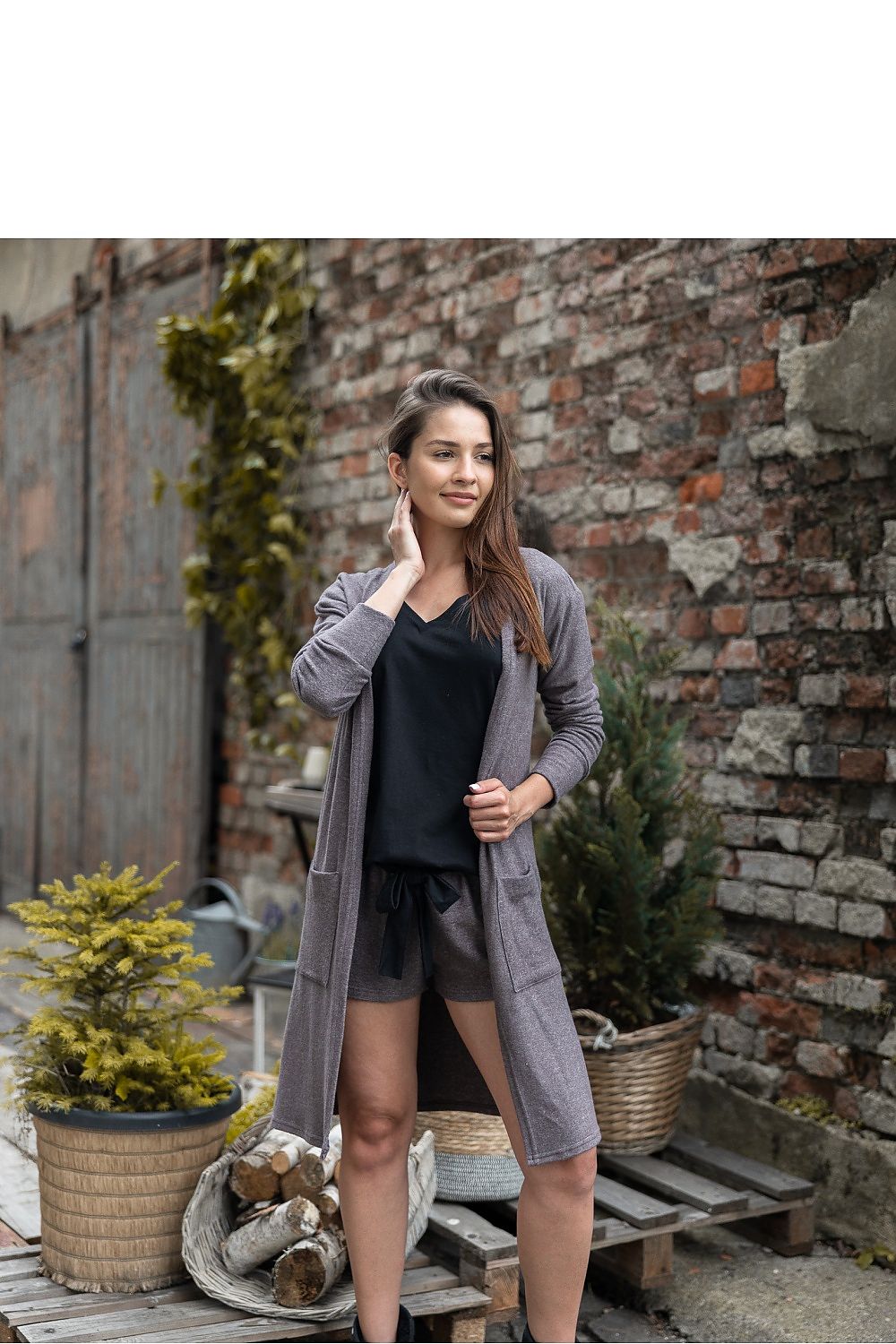 Luxury Brown Viscose Knitwear Cardigan with Pockets – Longer Style by Sensis, model showcasing the cardigan in an outdoor setting, styled with comfortable shorts and a chic black top.