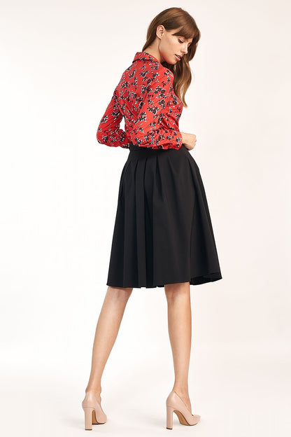Elegant A-Line Skirt With Belt and Pleats For Office & Casual Occasions By Nife, depicted from behind on a model highlighting the graceful flow and design of the black skirt paired with a red floral top.