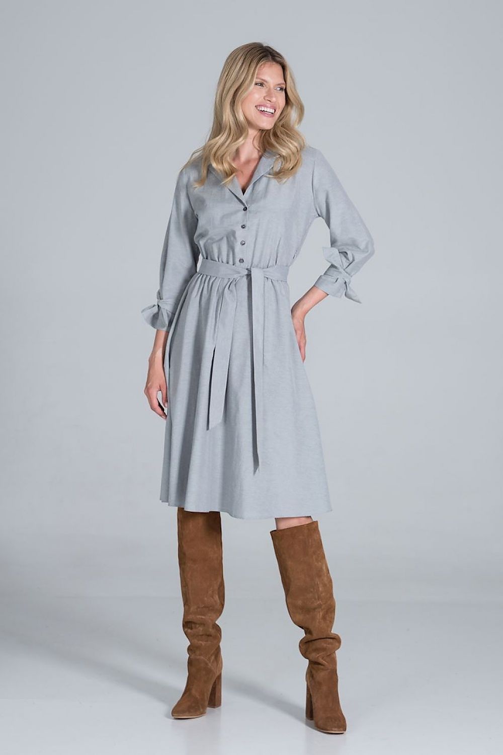 Elegant Midi Dress by Figl with Jacket-Style V-Neck, Flared Hem & Tie Belt, showcased in a light grey hue, elegantly styled with buttoned details and a tie belt, paired with knee-high, fashionable brown suede boots.