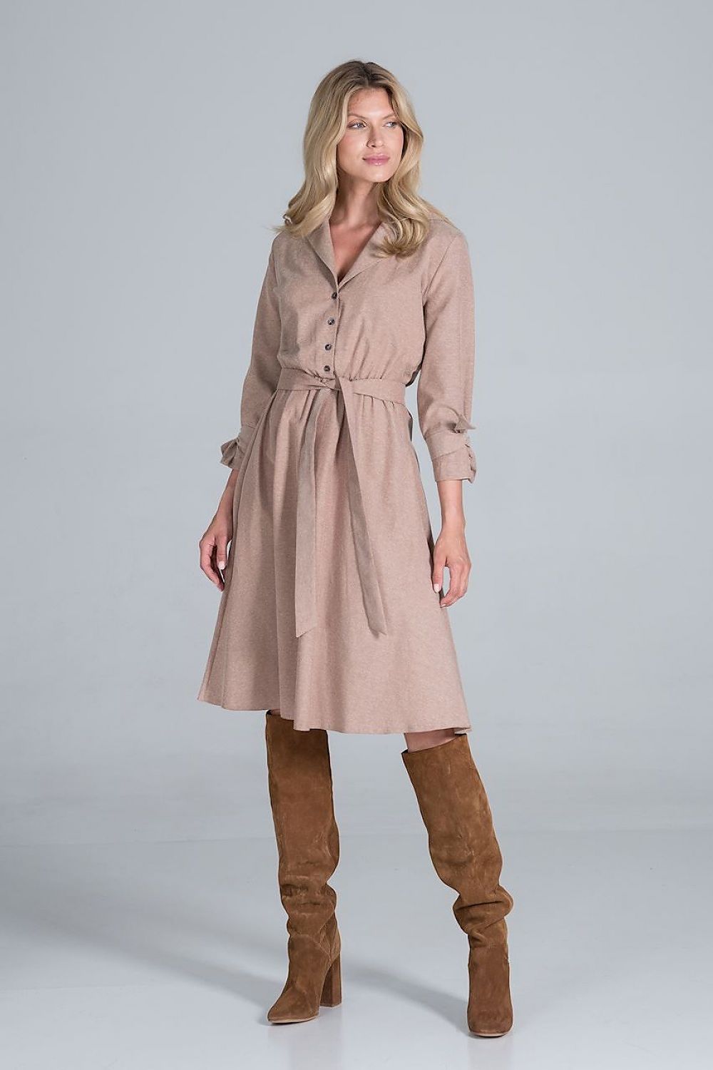Elegant Midi Dress by Figl in a fashionable pose, featuring a polished jacket-style v-neck, flared hem and tie belt, elegantly paired with knee-high suede boots.