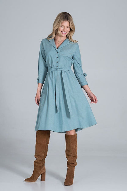 Elegant Midi Dress by Figl in a stunning blue hue, showcasing a jacket-style v-neck, flared design, and stylish tie belt, enhanced by chic high-heeled boots.