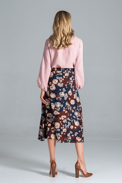 Back view of the Luxury Figl Blouse with half-round neckline and long sleeves, elegantly styled with a floral skirt.