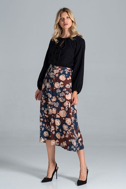 Stylish presentation of the Luxury Figl Blouse in black, showcasing the half-round neckline and long sleeves, elegantly combined with a floral skirt.