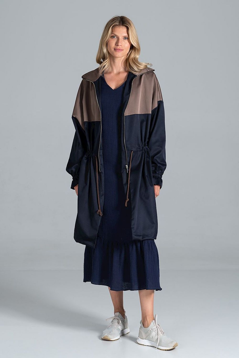 Elegant two-coloured autumn parka coat with drawstring waist and zip fastening by Figl, showcased in a frontal view with a model wearing a navy dress and sporty shoes.
