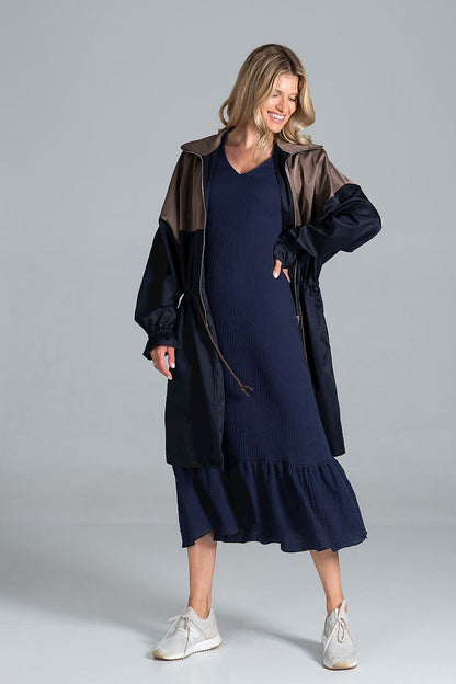 Charming expression of a model in the elegant two-coloured autumn parka coat with drawstring waist and zip fastening by Figl, paired with a navy dress and white sneakers.