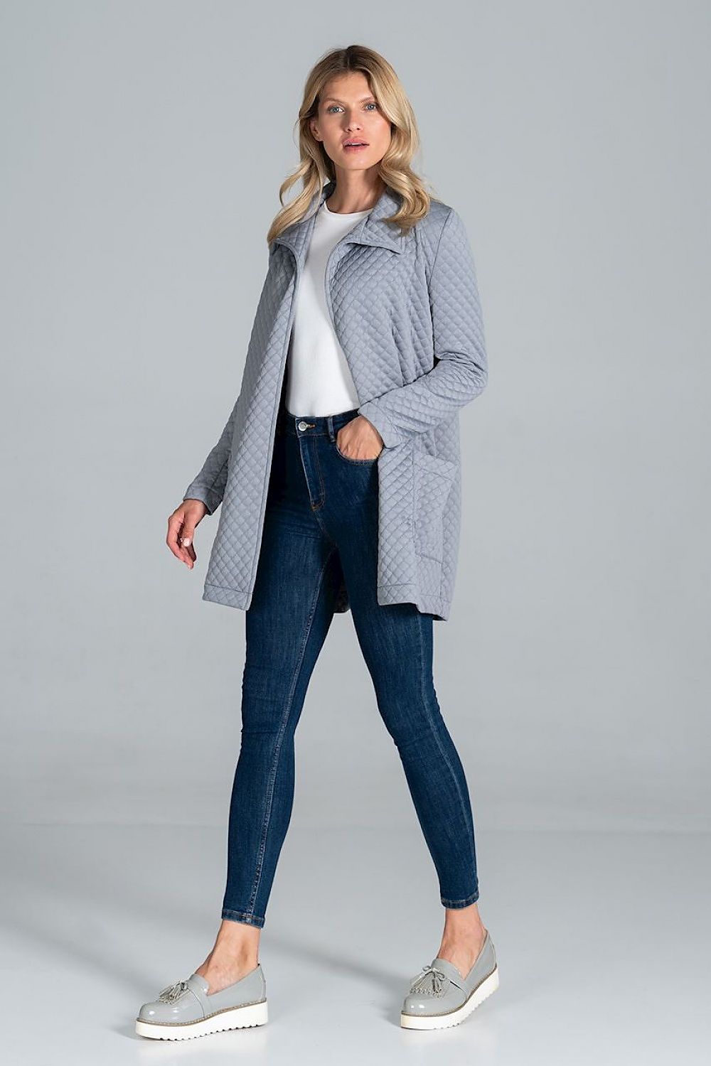Model showcasing the Figl Short Quilted Coat With Belt And Collar, featuring luxury style, unlined design, and front patch pockets, paired with sleek denim for a contemporary look.