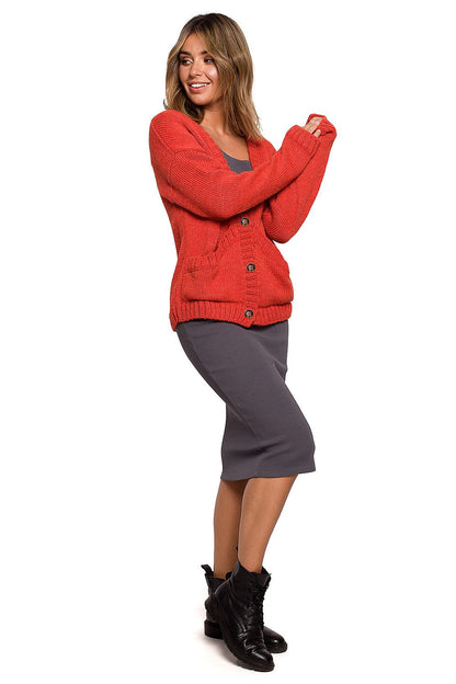 Elegant BE Knit Short Cardigan with Button Front and Pockets in red, model showcases a trendy autumn outfit paired with a grey dress and black boots.