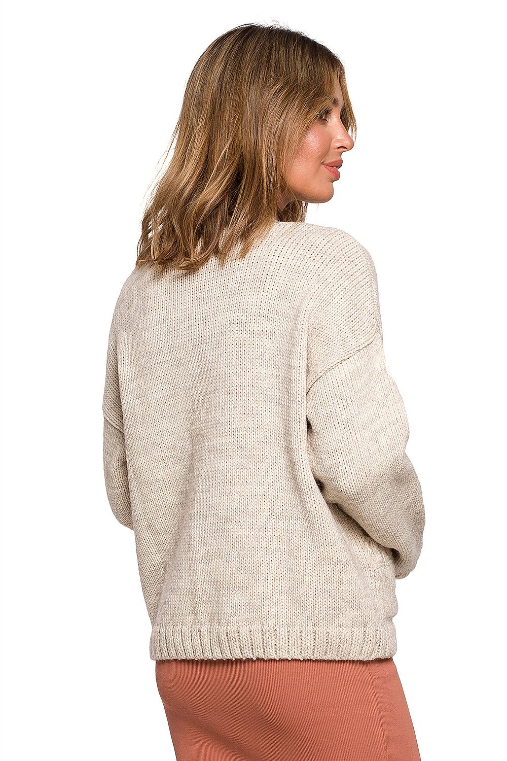 Elegant BE Knit Short Cardigan with Button Front and Pockets, presenting a model from the side in a beige cardigan, emphasising its luxurious texture and design for autumn elegance.