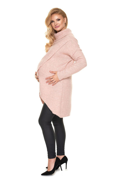 Luxurious Wool Blend Pregnancy Sweater with Turtleneck featuring an elegant asymmetrical design, showcased by a model in a soft pink colour, perfect for expecting mothers.
