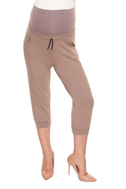 Chic pregnant model in light brown PeeKaBoo Elegant Fit Ribbed Cotton Maternity Crop Pants with Side Pockets, confidently displaying comfort and style.