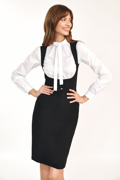 Elegant Nife Daydress in Feminine Fit showcased on a model, featuring a chic black design paired with a white blouse. Ideal for work and social outings, this versatile dress combines sophistication with style.