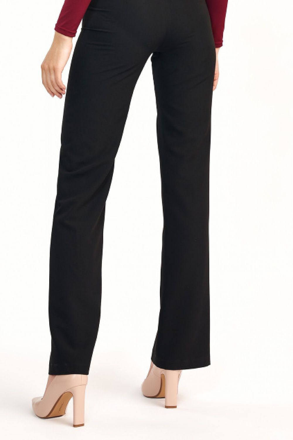 Back view of elegant women’s flared trousers with elevated waist by Nife, highlighting a sleek silhouette complemented by chic stiletto heels.
