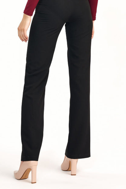 Back view of elegant women’s flared trousers with elevated waist by Nife, highlighting a sleek silhouette complemented by chic stiletto heels.
