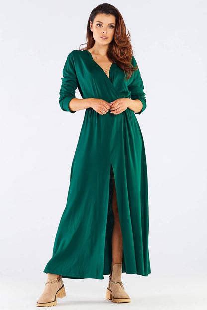 Elegant Long Sleeve Daydress in Viscose with Zip Detail, model wearing a striking green dress, perfect for colder days, showcasing feminine style and luxury, paired with trendy beige boots.