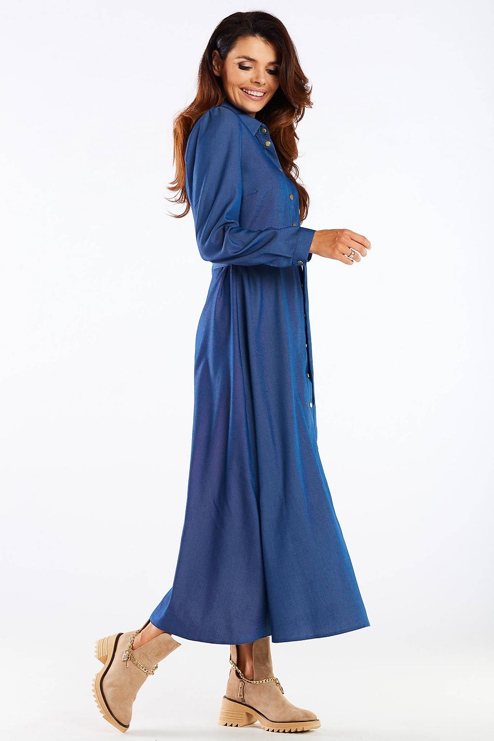 Stylish side profile of a maxi dress with buttoned trapeze bottom and collared belt, embodied in a plush blue fabric, reflecting the essence of contemporary luxury wear from Awama.