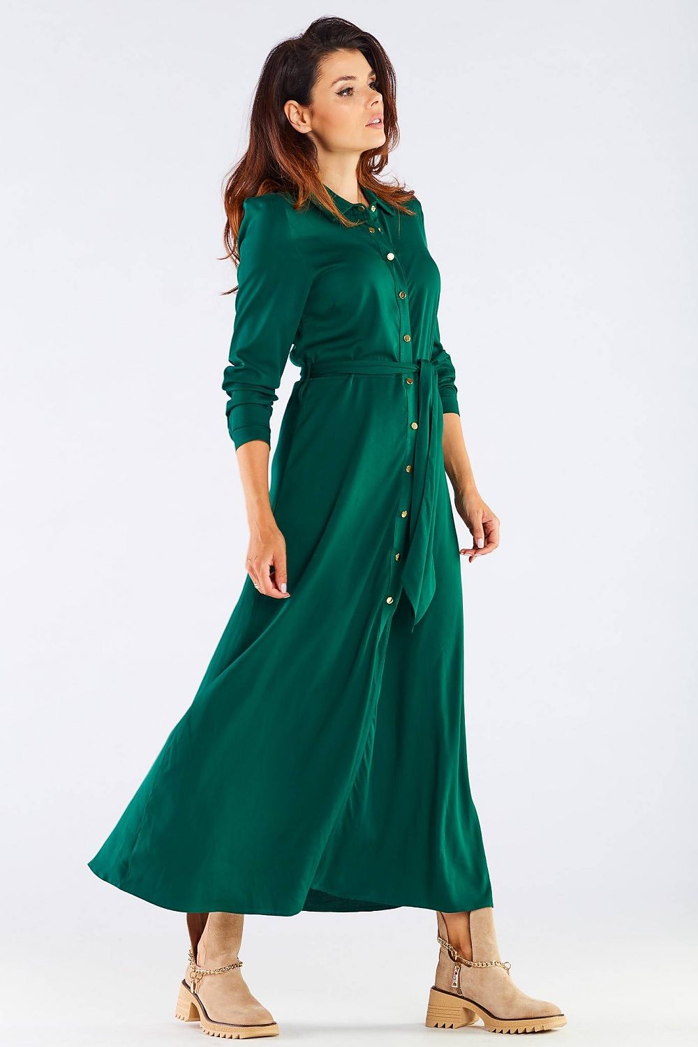 Dynamic side pose of the exquisite maxi dress with buttoned trapeze bottom and collared belt, model exuding elegance in the vibrant green dress, perfect for upscale occasions.