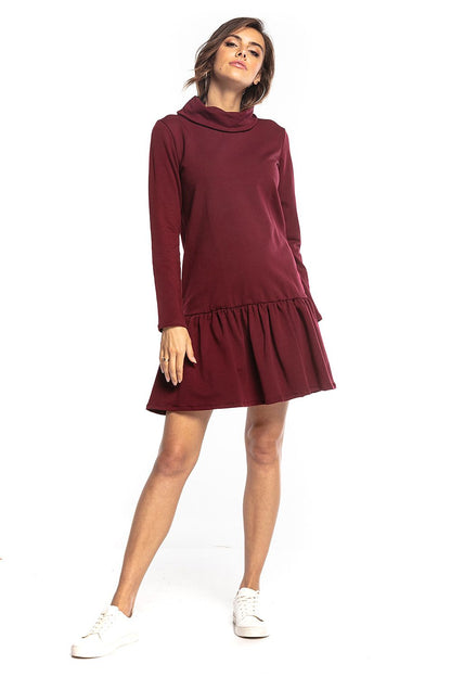 Elegant Tessita sporty midi dress in deep burgundy, featuring a turtleneck and frill hem, styled with white sneakers for a chic casual look.