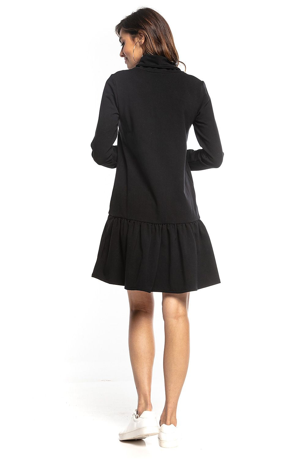 Back view showcasing the chic black Tessita sporty midi dress with turtleneck and frill hem, effortlessly styled with white sneakers.