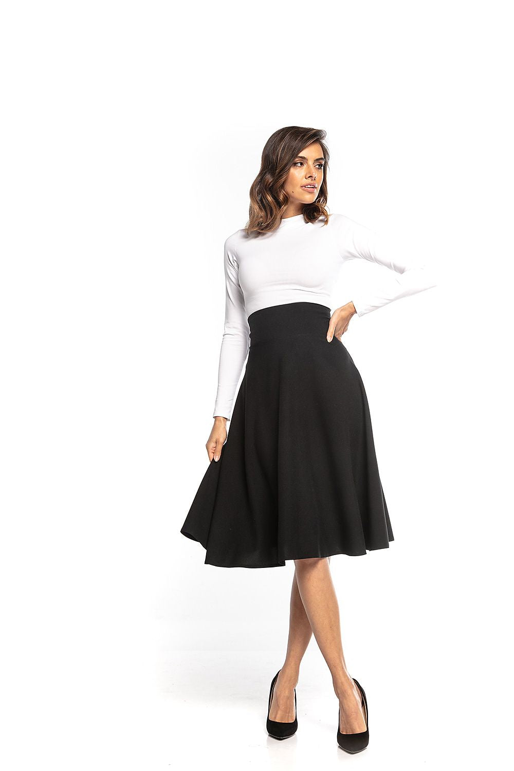 Tessita high-waisted black midi skirt elegantly styled with a fitted white long-sleeve top, showcasing a flattering silhouette for sophisticated fashion.