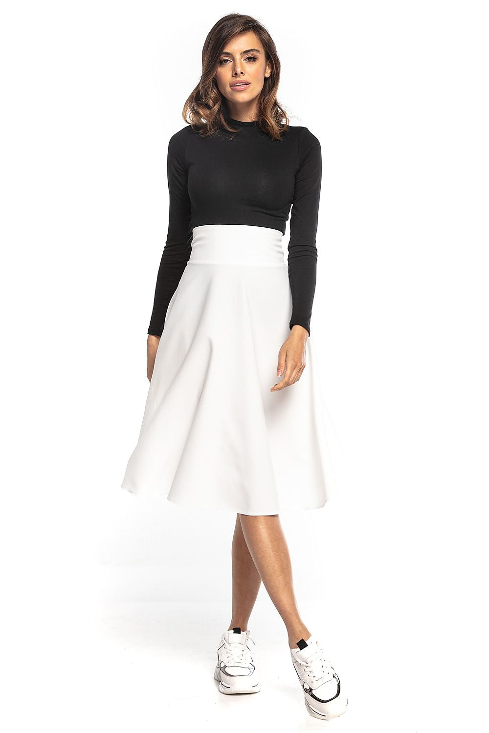 Elegant Tessita luxury midi skirt in white, featuring a high waist and full silhouette, styled with a fitted black top and trendy sneakers.