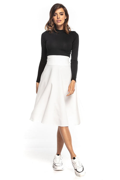 Elegant Tessita luxury midi skirt in white, featuring a high waist and full silhouette, styled with a fitted black top and trendy sneakers.