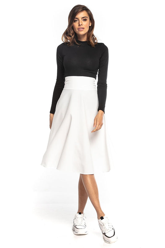 Elegant Tessita luxury midi skirt in white, featuring a high waist and full silhouette, styled with a fitted black top and trendy sneakers.