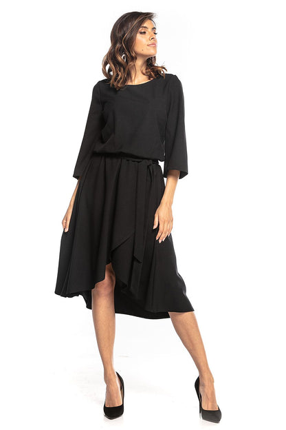Stylish model showcasing the elegant asymmetrical midi dress with 3/4 sleeves and belt by Tessita, featuring a modern silhouette and chic design elements.