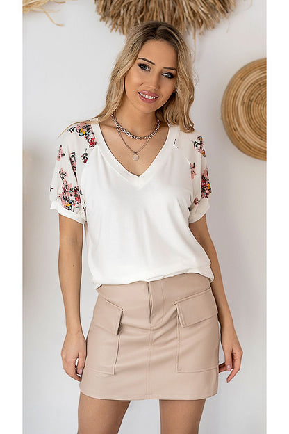 Elegant cream Hajdan blouse made of smooth viscose knit with stylish floral printed sleeves, combined with a trendy beige mini skirt for a luxurious outfit.