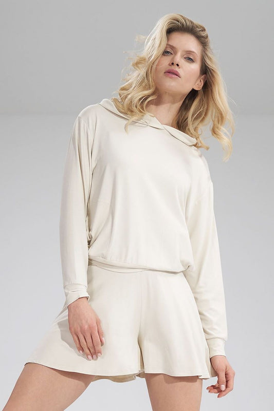 Luxury Figl shorts in soft beige fabric, featuring a wide elastic waistband, styled with a matching long-sleeve top for an elegant casual look.