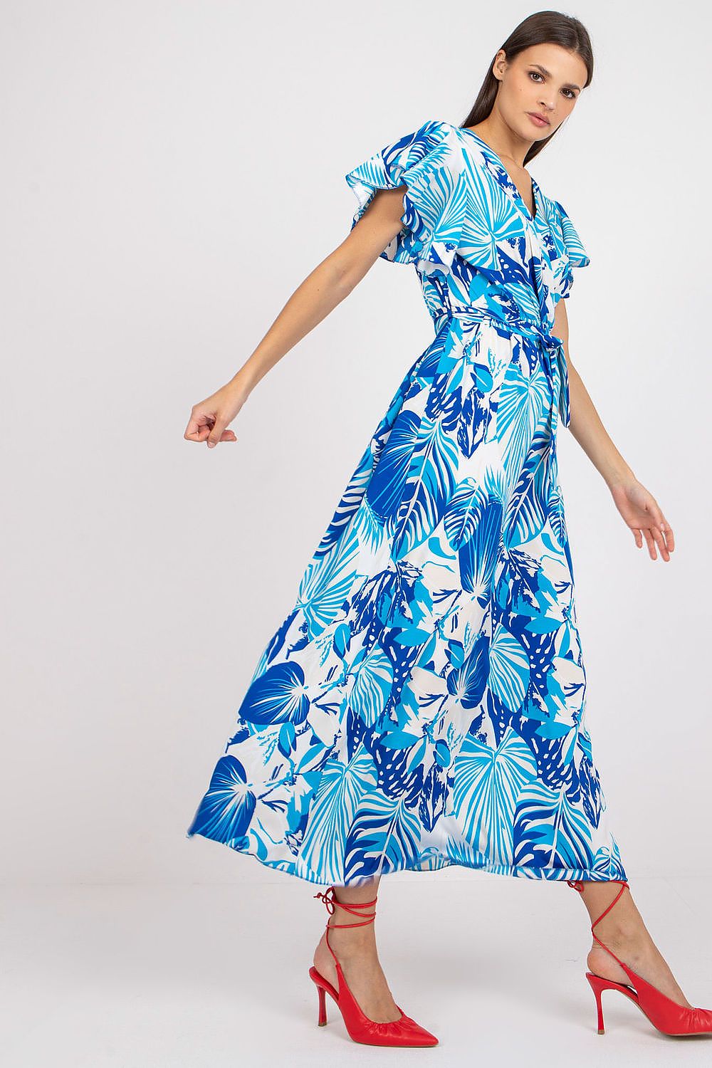 Graceful model in a sophisticated blue floral dress with an envelope neckline and waist tie, demonstrating luxurious casual wear for various occasions.