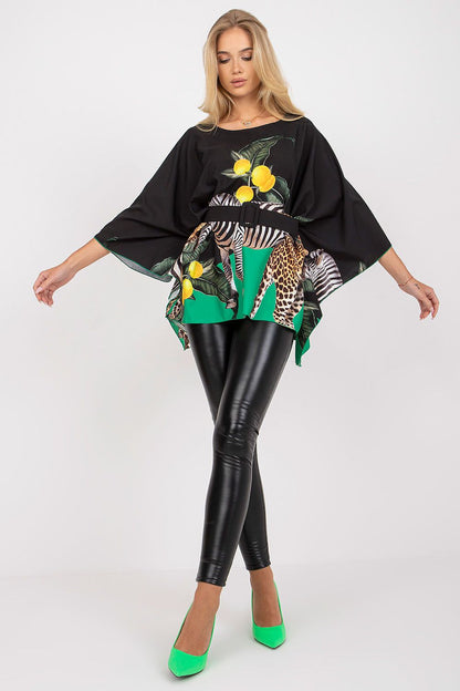 Luxurious Italy Moda loose cut blouse featuring vibrant citrus and animal print patterns, elegantly styled with a belt, paired with sleek black leggings and striking green heels, perfect for sophisticated fashion moments.