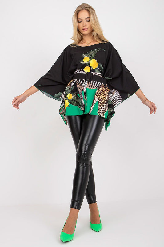 Luxurious Italy Moda loose cut blouse featuring vibrant citrus and animal print patterns, elegantly styled with a belt, paired with sleek black leggings and striking green heels, perfect for sophisticated fashion moments.