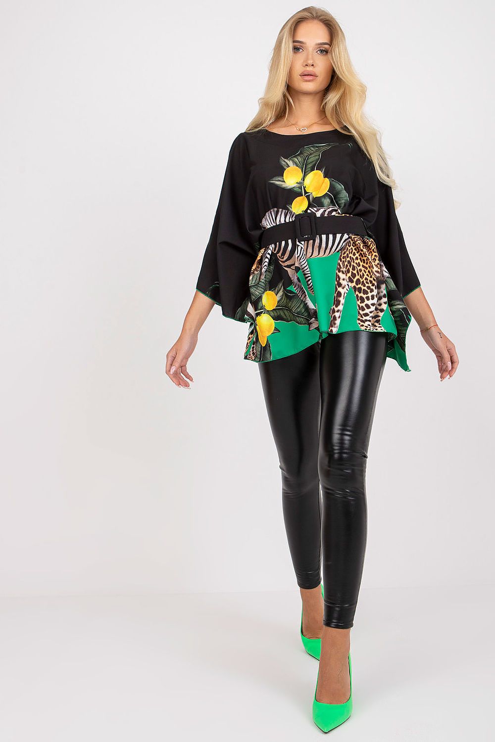 Stylish Italy Moda loose cut blouse with vibrant patterned fabric featuring lemon and animal print, combined with high-waisted black leggings and green heels, perfect for a chic fashion statement.