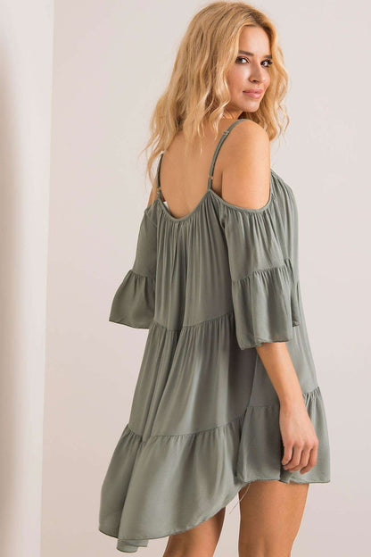Graceful green summer dress with off-shoulder design, highlighted by frills and flowing fabric, a perfect choice for summer celebrations.