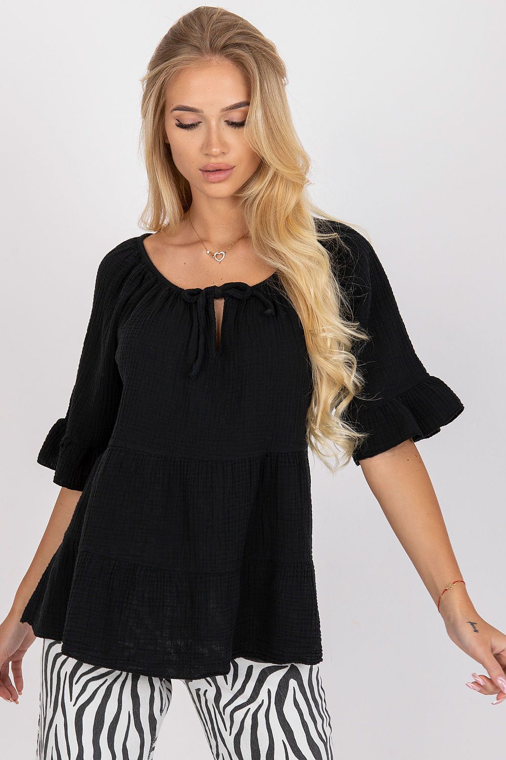 Elegant black loose fit cotton blouse featuring ruffled sleeves and a charming tied neckline, styled for a sophisticated everyday look.