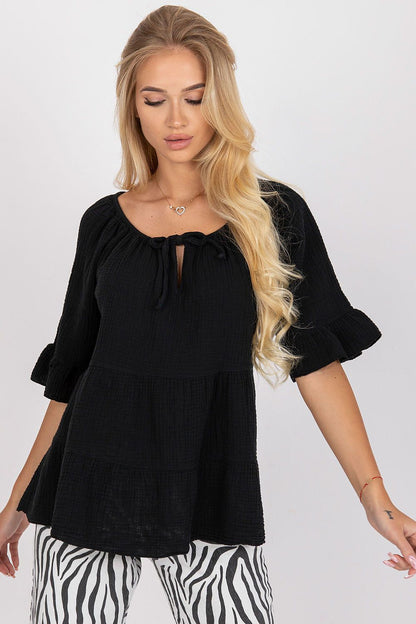 Elegant black loose fit cotton blouse featuring ruffled sleeves and a charming tied neckline, styled for a sophisticated everyday look.